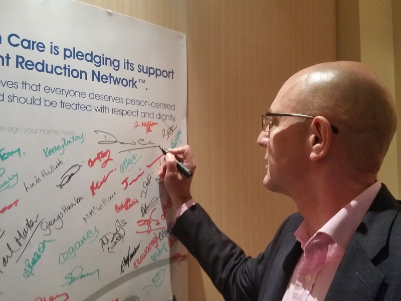 Chief Executive David Cole signing his support for reducing restrictive practice